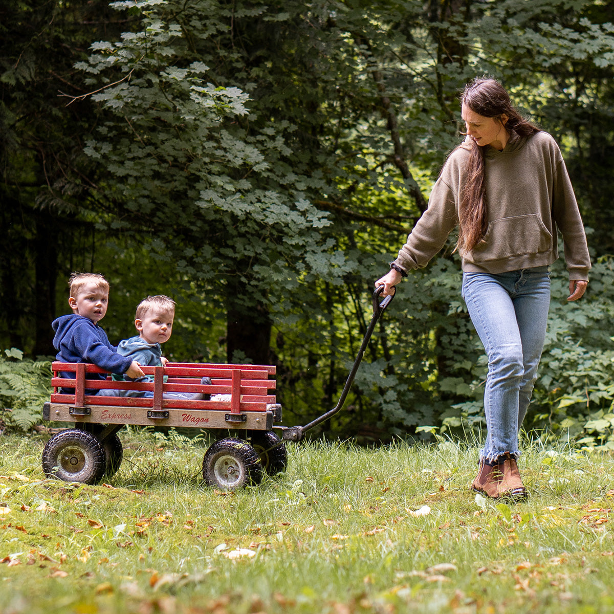 Mom pulling boys in Padraig Slippers on wagon