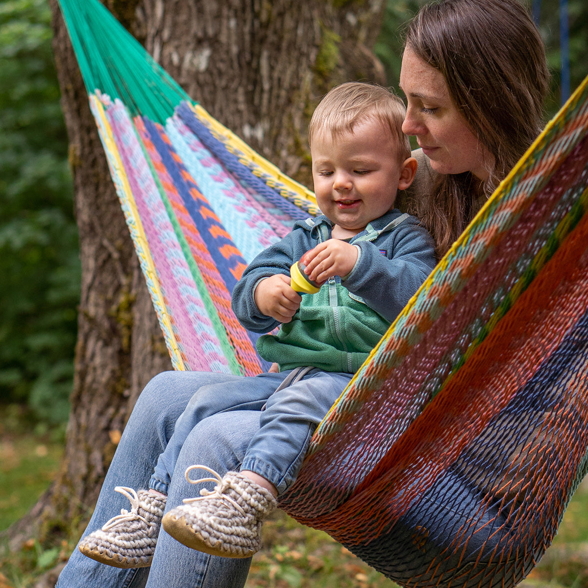Mom with little boy sitting on hammock wearing Padraig Slippers