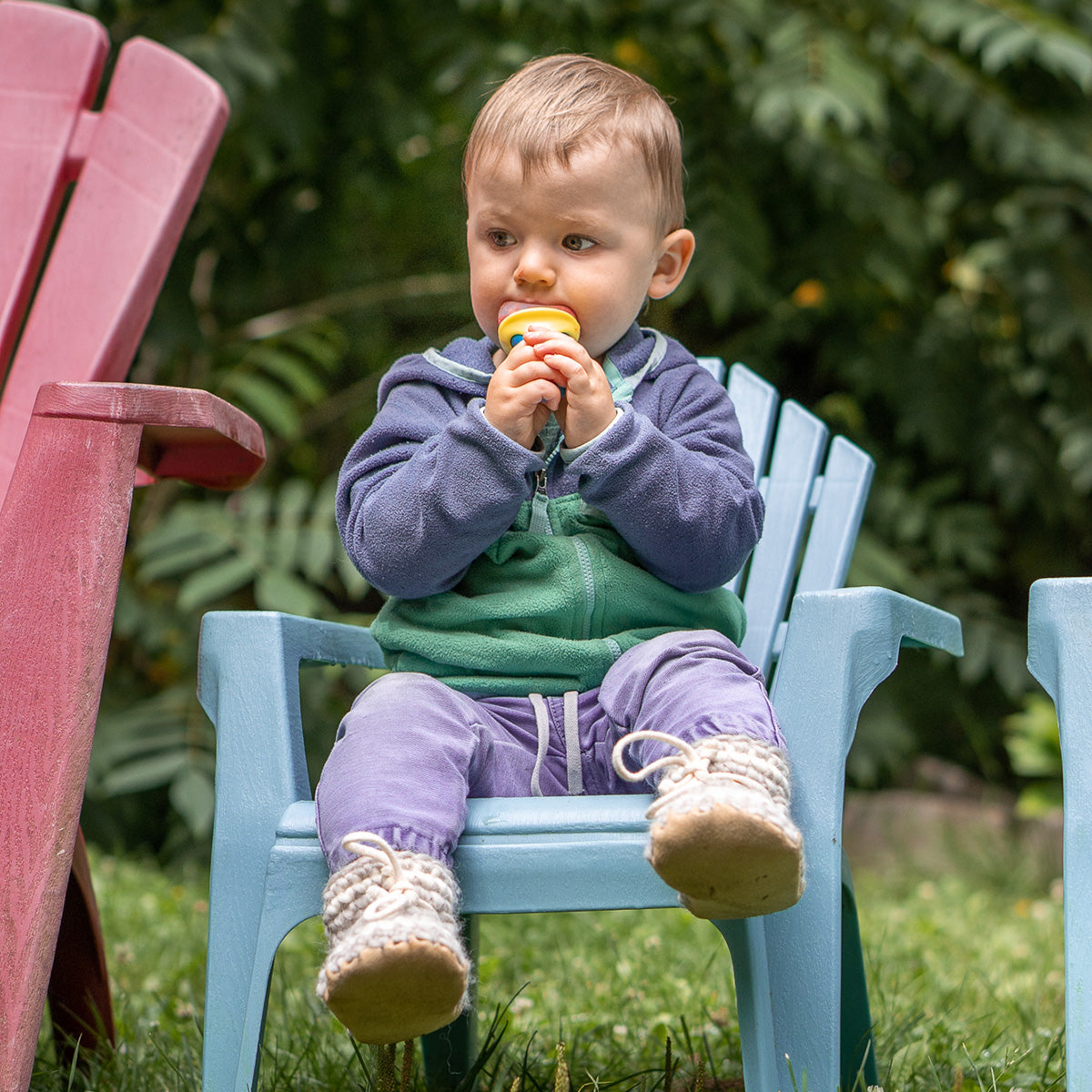 Little boy sitting on chair eating popsicle wearing Padraig Slippers