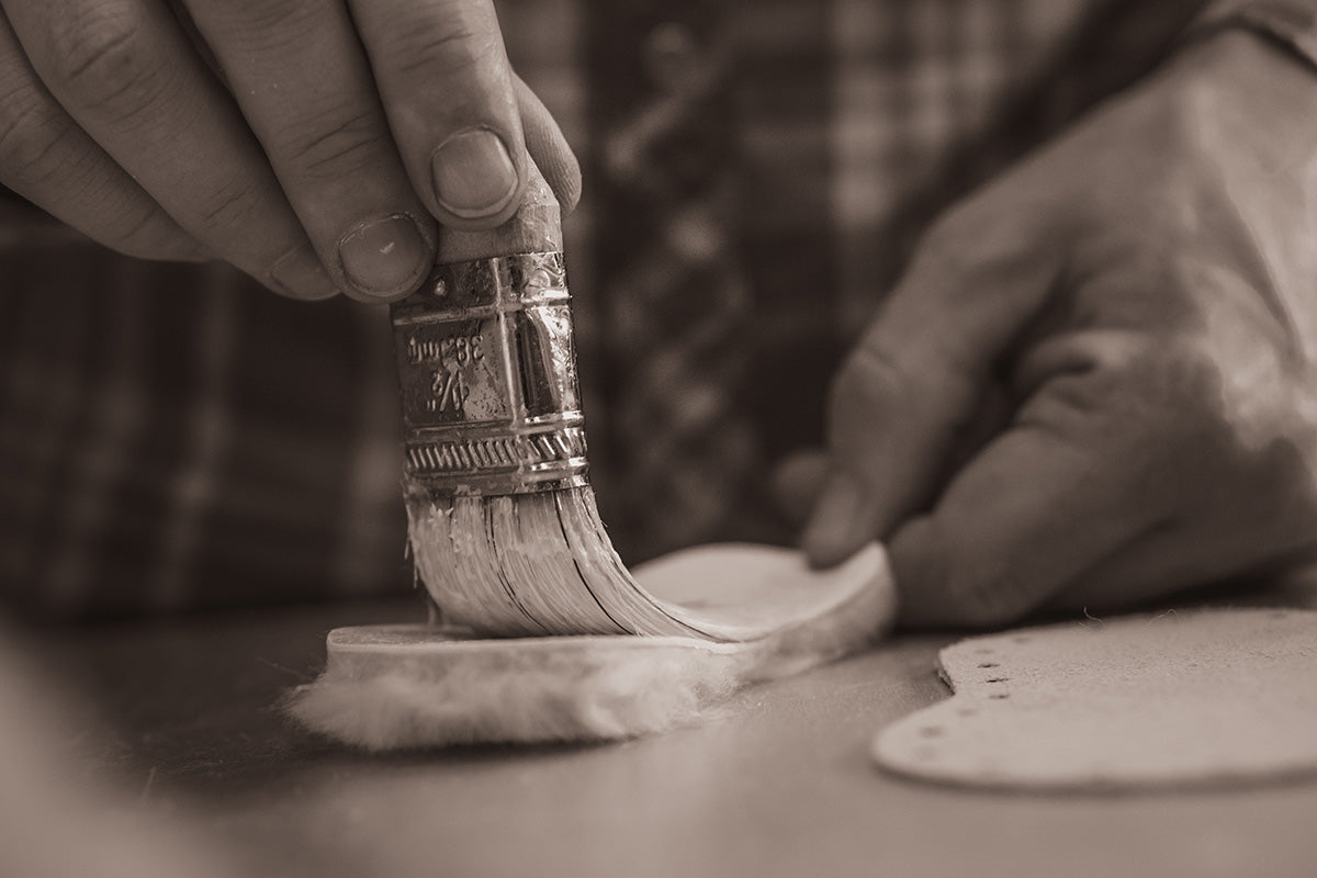 Applying natural latex to sole of Padraig slipper